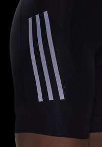 Black athletic shorts with three vertical reflective stripes on the side. Features a fitted design and textured fabric around the waist.