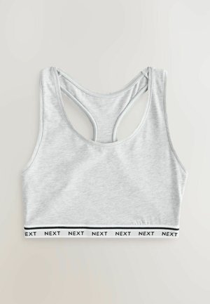 Grijs katoenen sportbeha met een racerback-ontwerp. Heeft een contrasterende witte tailleband met "NEXT" in het zwart gedrukt. Gladde textuur.