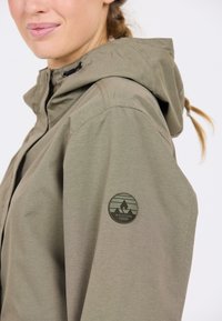 Olijfgroene hoodie gemaakt van een gladde stof, met een logopatch op de linker mouw en een verstelbare trekkoord bij de hals.