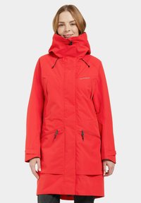 Manteau imperméable rouge avec un col haut, une capuche ajustable, des poches zippées et une coupe décontractée. Présente une finition mate et un tissu résistant.