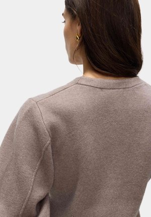 Suéter marrón claro con una textura suave, que presenta un cuello redondeado clásico y costuras de hombro caídas, mostrando un diseño liso.