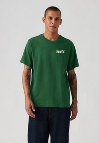 Tricou verde cu mânecă scurtă, fabricat din bumbac, cu guler rotund. Prezentă un logo alb „levi's” imprimat pe partea stângă a pieptului.