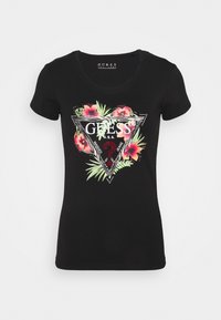 Sort kortærmet t-shirt med et blomster hjerte grafik, der har mærket "GUESS" i hvid samt farvede tropiske blomster og et trekantet design.