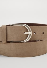 Ceinture en daim marron dotée d'une boucle en métal argenté, à texture plate et comportant plusieurs trous pour un ajustement. Enroulée de manière circulaire.