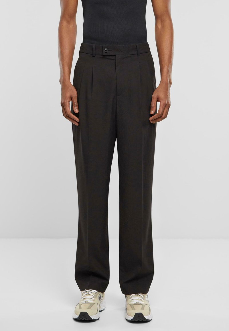 Pantalones plisados negros fabricados con un tejido suave. Cuentan con una cintura ajustada con cierre de botón y un diseño de pierna recta.