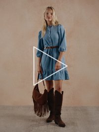 Džinsa kleita ar pogu priekšpusē, pūkainām piedurknēm un volānu malu. Brūna zamšādas soma ar bārkstīm un augsti brūni zamšādas zābaki ar papēžiem.