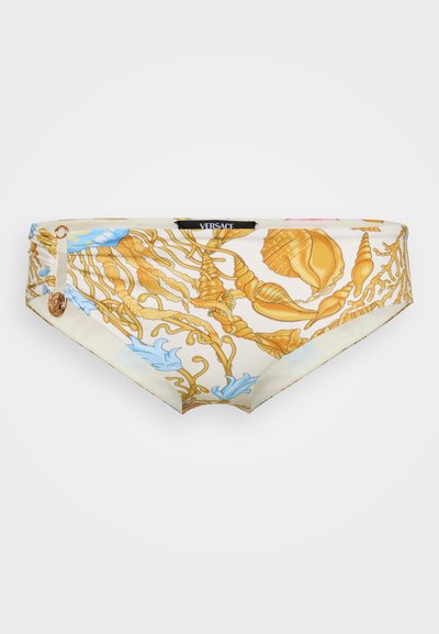 Bikiny Versace s krémovým základom, ktorý je ozdobený zlatými mušľami a modrým vzorom morskej riasy. Má hladkú textúru a zakrivený tvar.