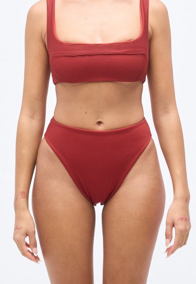 Ensemble bikini rouge côtelé comprenant un haut à encolure carrée et un bas taille haute. Le tissu présente un motif texturé et une coupe ajustée.