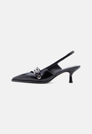 Scarpa slingback con tacco kitten in vernice nera, punta a punta e dettaglio fibbia argentata, su sfondo bianco semplice.