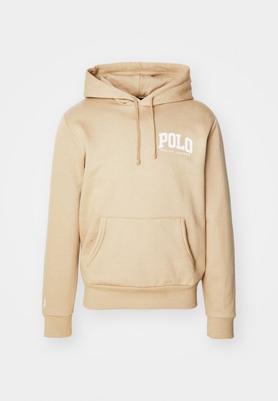 Hoodie beige avec une poche kangourou, capuche à cordons et logo "POLO" en blanc sur la poitrine. Tissu lisse avec des poignets et un ourlet côtelés.