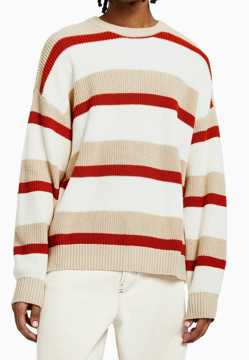 Randig stickad tröja med röda, beige och vita horisontella ränder, ribbat mönster och rund halsdesign.
