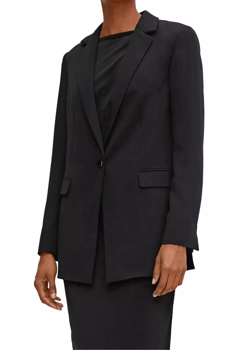 Blazer noir sur mesure avec une fermeture à un bouton, des revers crantés et deux poches avant. Tissu lisse avec une silhouette structurée.