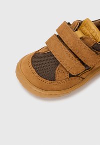 Brown suede and mesh toddler shoe with two Velcro straps, rounded toe, and textured rubber sole. Reinforced stitching details throughout.