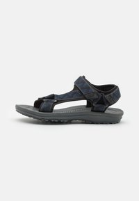Sorte og blå utendørs sandaler med justerbare stropper, teksturert fotseng og en robust grå såle med et mønster for godt grep.