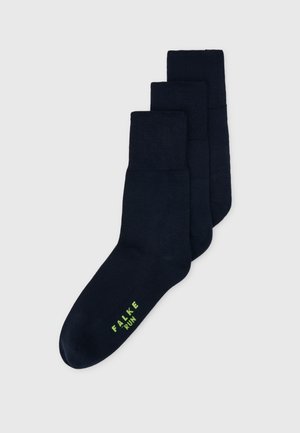 Marina blå löparstrumpor gjorda av ett mjukt, stretchigt material. Har en enkel design med en grön "FALKE RUN"-logotyp. Tre par staplade.