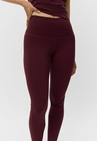 Bordinės kelnės iš glotnios, elastingos medžiagos, su aukštu liemeniu ir elegantišku prigludimu per kojas. Matomi minimalūs siuvimo detalės.