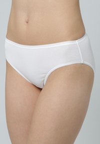 Witte katoenen bikini slipjes met een gladde textuur, voorzien van een middelgrote tailleband en minimale stiksels voor een eenvoudig ontwerp.