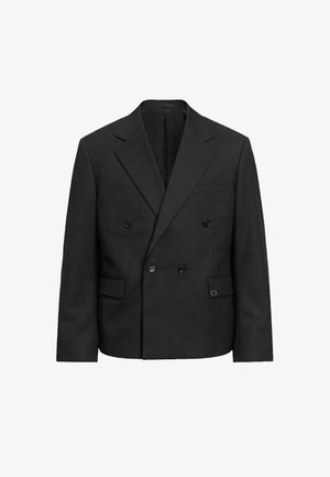 Blazer negro cruzado con solapas con muesca, cuatro botones, dos bolsillos con solapa y un bolsillo de ojal en el pecho, presentado sobre un fondo blanco.