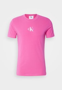 Růžové bavlněné tričko s krátkým rukávem, na hrudi s bílým logem Calvin Klein. Hladká textura, klasický výstřih.