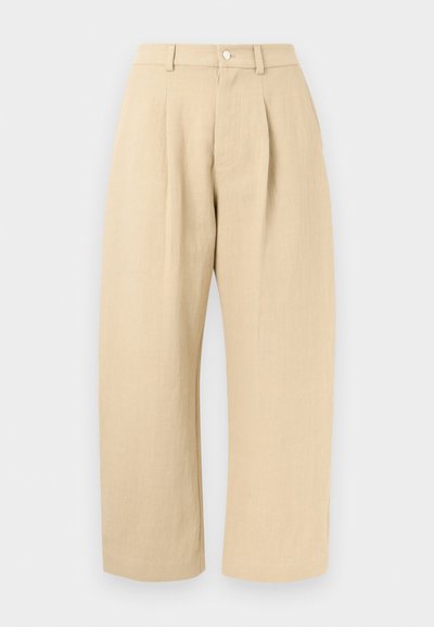 Pantalon beige taille haute à jambes larges avec passants pour ceinture, fermeture à boutons à l'avant, et poches latérales sur un fond clair.