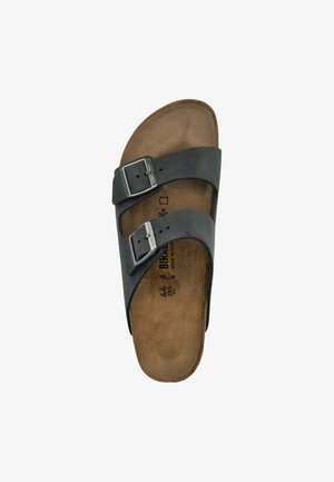 Must mustreteks mustrilin kaks reguleeritavat rihma ja hõbedaste klipsidega, millel on pruun pehmendusega tallaplaat ja kontuuritud kuju.