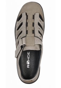 Šedé semišové sandály s proříznutým designem, nastavitelným páskem a černými akcenty. Obsahují polstrovanou černou stélku s logem.