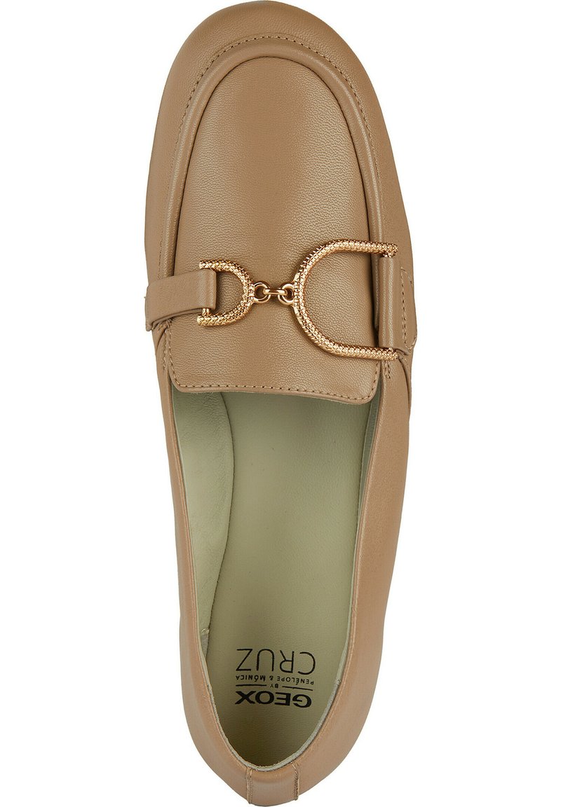 Beige leren instapper met een ronde neus, gestikte randen en een gouden decoratieve kettingaccents langs de voorkant. Zachte binnenvoering.