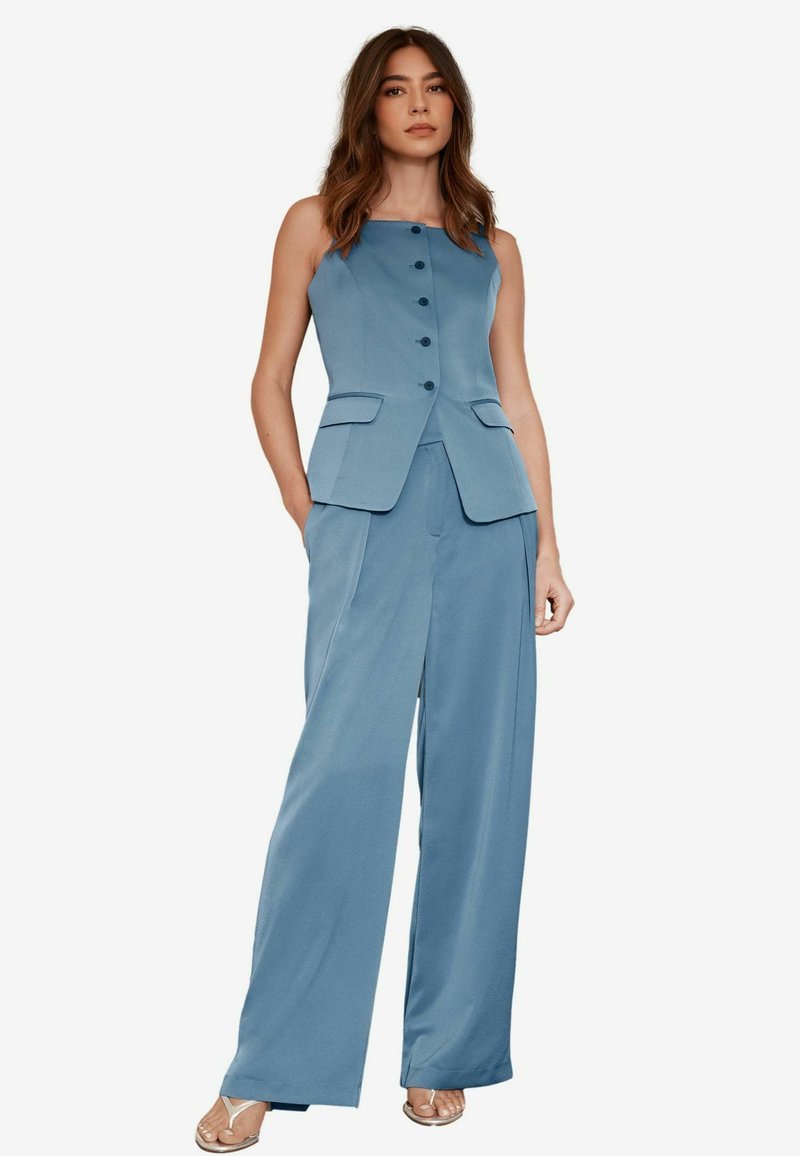 Blue sleeveless blazer with front buttons and pockets, paired with wide-leg matching trousers, showcasing smooth fabric and tailored fit.