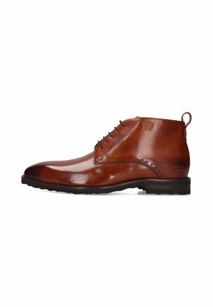 Botines de cuero marrón con textura suave, punteras redondeadas y diseño de cordones con seis orificios. Presentan un logo grabado y suela de goma resistente.