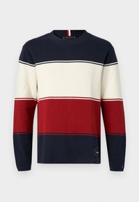 Pull rayé marine, crème et rouge avec texture côtelée et col ras du cou. Bandes horizontales de couleur de largeurs variées. Étiquette visible à l'ourlet.