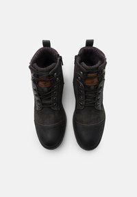 Stivali ankle in suede nero con dettagli in pelle, punta rotonda, occhielli in metallo e rivestimento interno testurizzato. Presenta lacci e cerniere laterali.