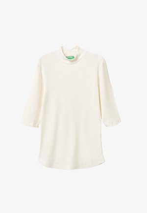 Top à col roulé côtelé de couleur crème avec des manches trois-quarts. Texture douce, coupe décontractée et ourlet arrondi. Étiquette verte au niveau de l'encolure.