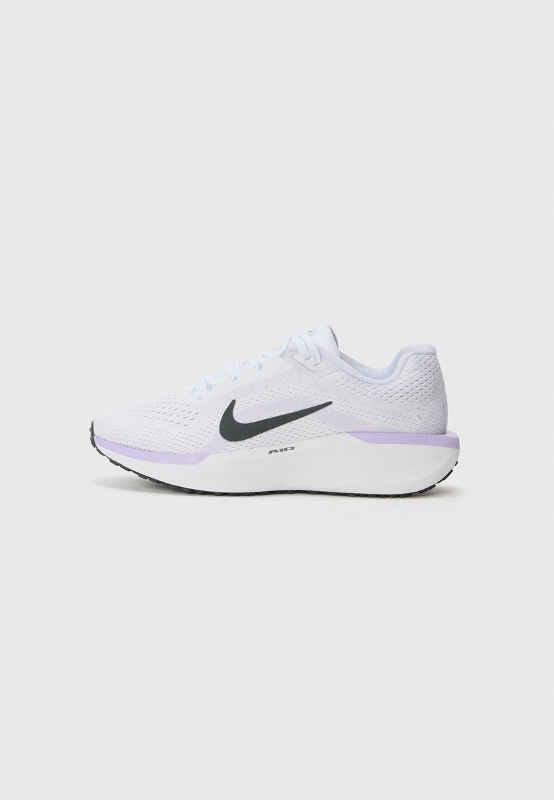 Hvite sportssko med et pustende mesh-overdel, svart Nike swoosh, lys lilla detaljer på sålen, og en teksturert svart gummimellomsåle.