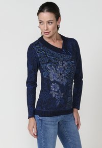 Navy Pullover mit langen Ärmeln, V-Ausschnitt und floralem Stickmuster in Blau- und Silbertönen. Rippbündchen und Saum.