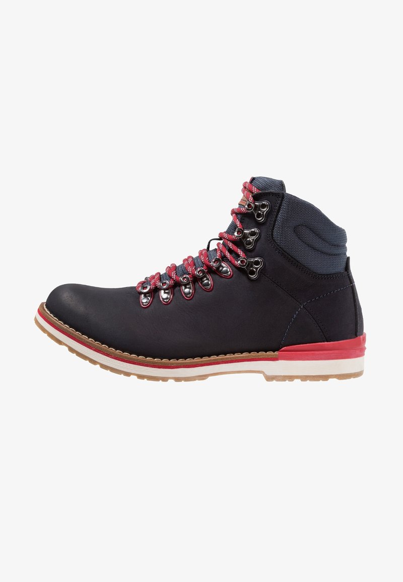 Botte de randonnée noire avec semelle rouge et blanche, col matelassé gris et lacets rouges passés dans des œillets et crochets en métal.