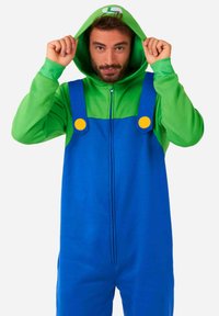 Monopiece con capucha en verde y azul, con botones amarillos en los tirantes, fabricado en un tejido suave, cierre de cremallera y logotipo en la capucha.
