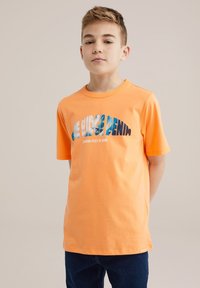 Oranžinė medvilninė marškinėliai su mėlynos ir juodos spalvos grafiniu tekstu "Blue Ridge Denim", trumpomis rankovėmis ir apvaliu kaklu.
