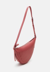 Rosa läderaxelväska med rundad form, liten dragkedjeöppning och justerbar rem. Strukturerad yta med minimala sömdetaljer.