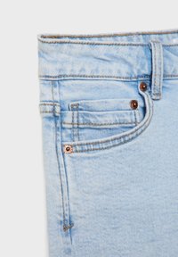 Vaaleansiniset farkut slim fit -mallilla, joissa on kuparinväriset yksityiskohdat, pieni etutasku ja eriväriset ompeleet saumoissa.