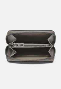 Cartera de cuero gris con un diseño de cierre alrededor, que cuenta con dos compartimentos y un bolsillo central con cremallera. Forro interior suave, hardware mínimo.