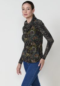 Langärmliges Oberteil mit Schalkragen aus schwarzem Stoff, das bunte Blumen- und geometrische Muster zeigt. Dehnbare, enganliegende Silhouette mit aufwendigen Details.