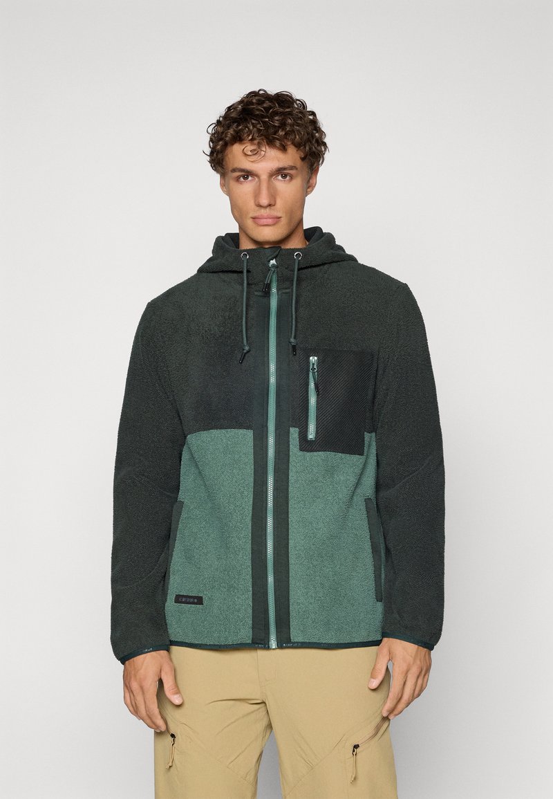 Fleece dukserica s kapuljačom u tamnozelenoj i tirkiznoj boji, koja ima patentni zatvarač sprijeda, podesivu kapuljaču s vezicom i crnu zip džep na prsima.