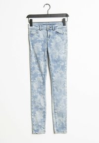 Light blue skinny jeans featuring a floral print pattern, made of denim. They have a classic five-pocket design and a standard zip fly.