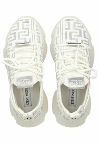 Zapatillas deportivas blancas con una parte superior texturizada y un patrón geométrico plateado, puntera redonda y una suela blanca gruesa. Los cordones están atados de manera ordenada.