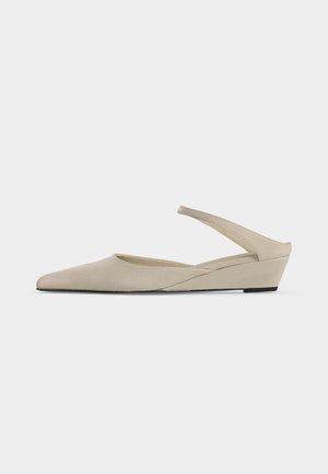 Beige lav kilehæl slingback sko med spids tå og glat mat finish, vist i sideprofil på hvid baggrund.