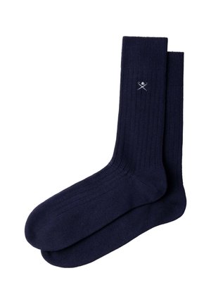 Pair of navy blue ribbed socks with a small white crossed sword and skull emblem near the top cuff.