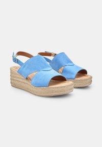 Sandali con plateau in suede blu, con cinturini incrociati, punta aperta e suola piattaforma beige testurizzata, dotati di una fibbia sul tallone.