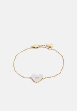 Goldene Kettenarmband mit einem herzförmigen weißen Stein in der Mitte, der ein Sonnenstrahlenmuster aufweist, gesichert mit einem Karabinerverschluss.