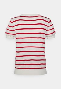 Camiseta de punto de manga corta a rayas en crema con rayas horizontales rojas. Cuenta con cuello redondo y aberturas en los lados del dobladillo. Fabricada con material suave.