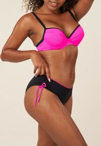 Ensemble de bikini comprenant un haut rose fluo à motif texturé avec des bretelles noires réglables ; bas noirs avec des accents roses et un détail de nouage.
